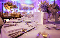 Table set with glasses, cutlery, and napkins from a Ely's Fine Foods catering event