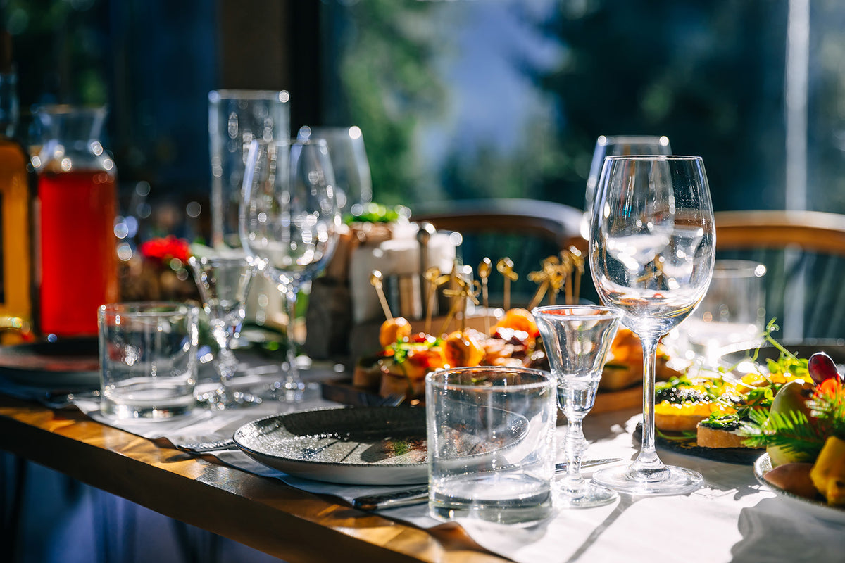 Table layout with wine glasses, or d'oeuvres, plates, and beverages 