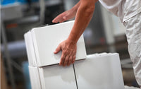 a wholesale worker stacking boxes of kosher meals to prepare them for delivery in Toronto